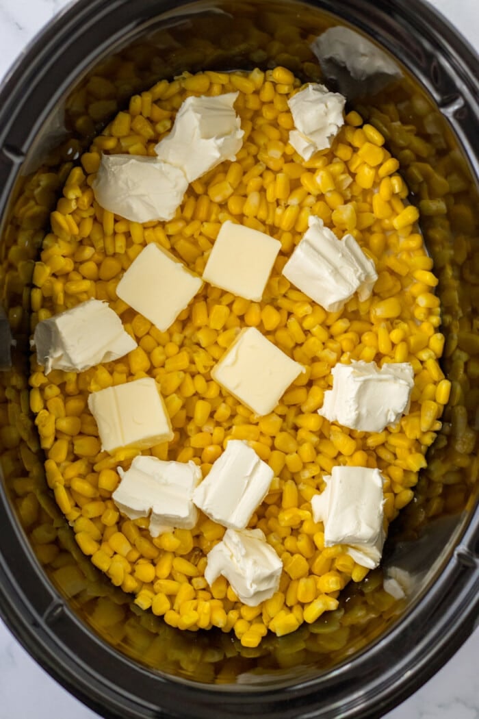 cream cheese and butter on top of corn in crock pot