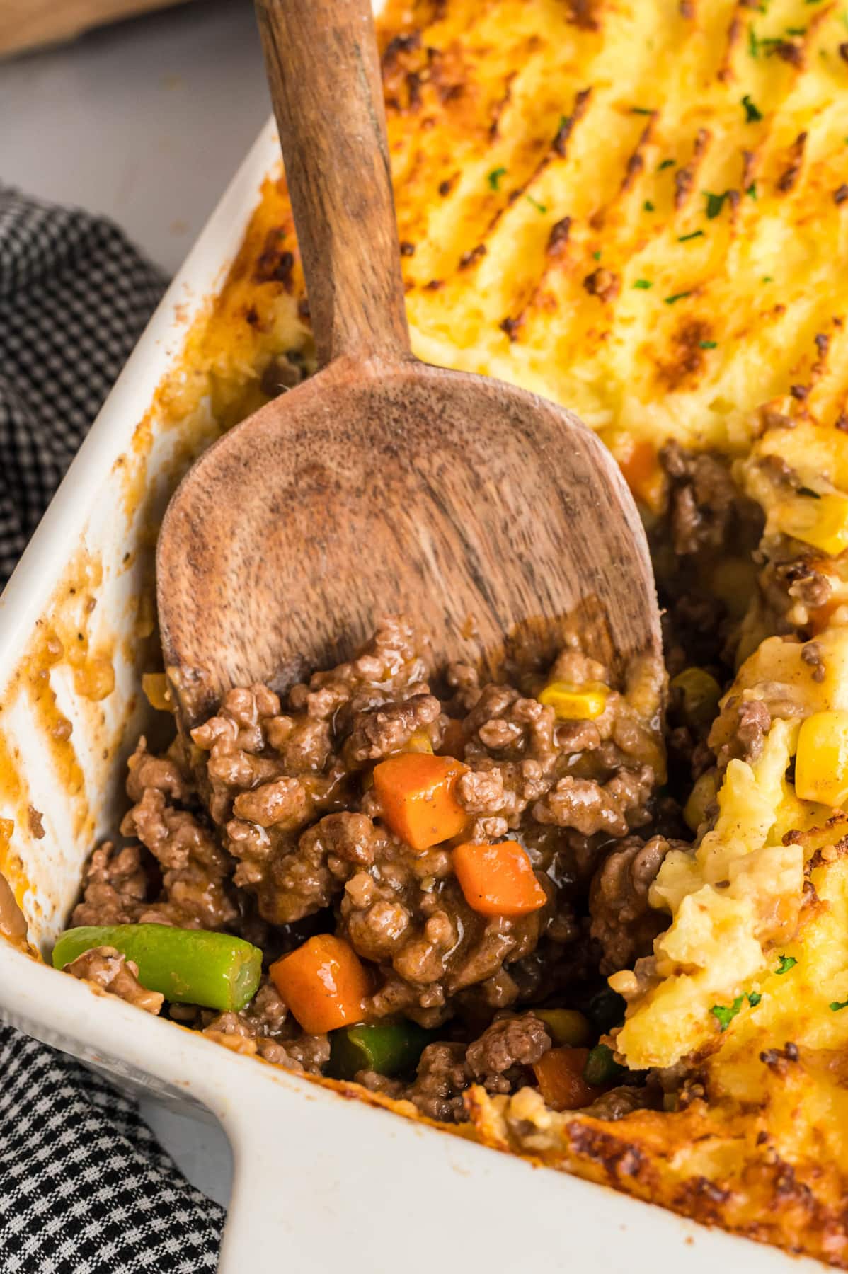 A wooden spoon in a dish of cottage pie