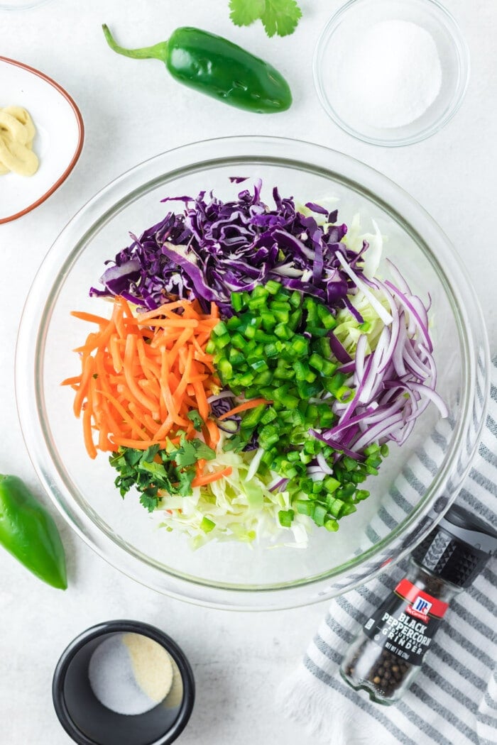 glass bowl with cut ingredients for jalapeno coleslaw