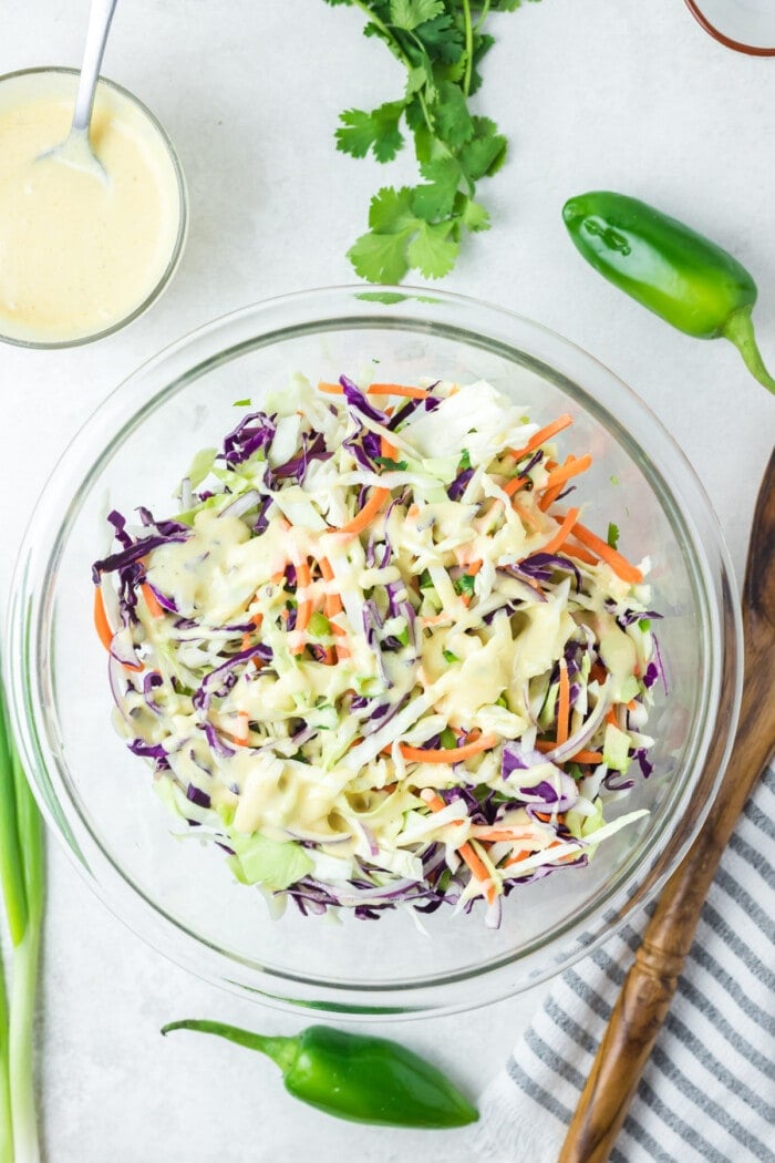jalapeno coleslaw in glass bowl with dressing