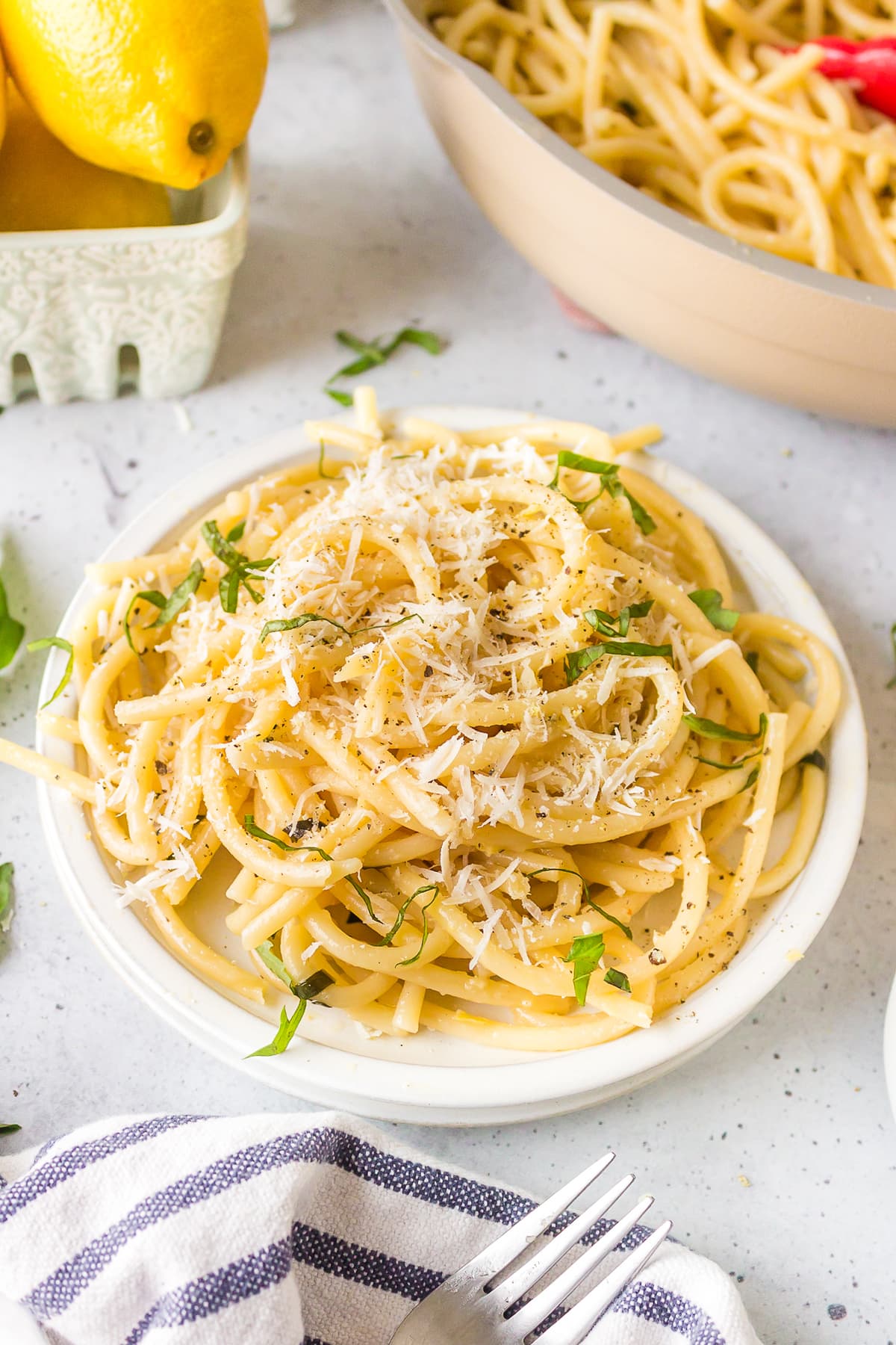 lemon garlic pasta served on white plate with parmesan cheese