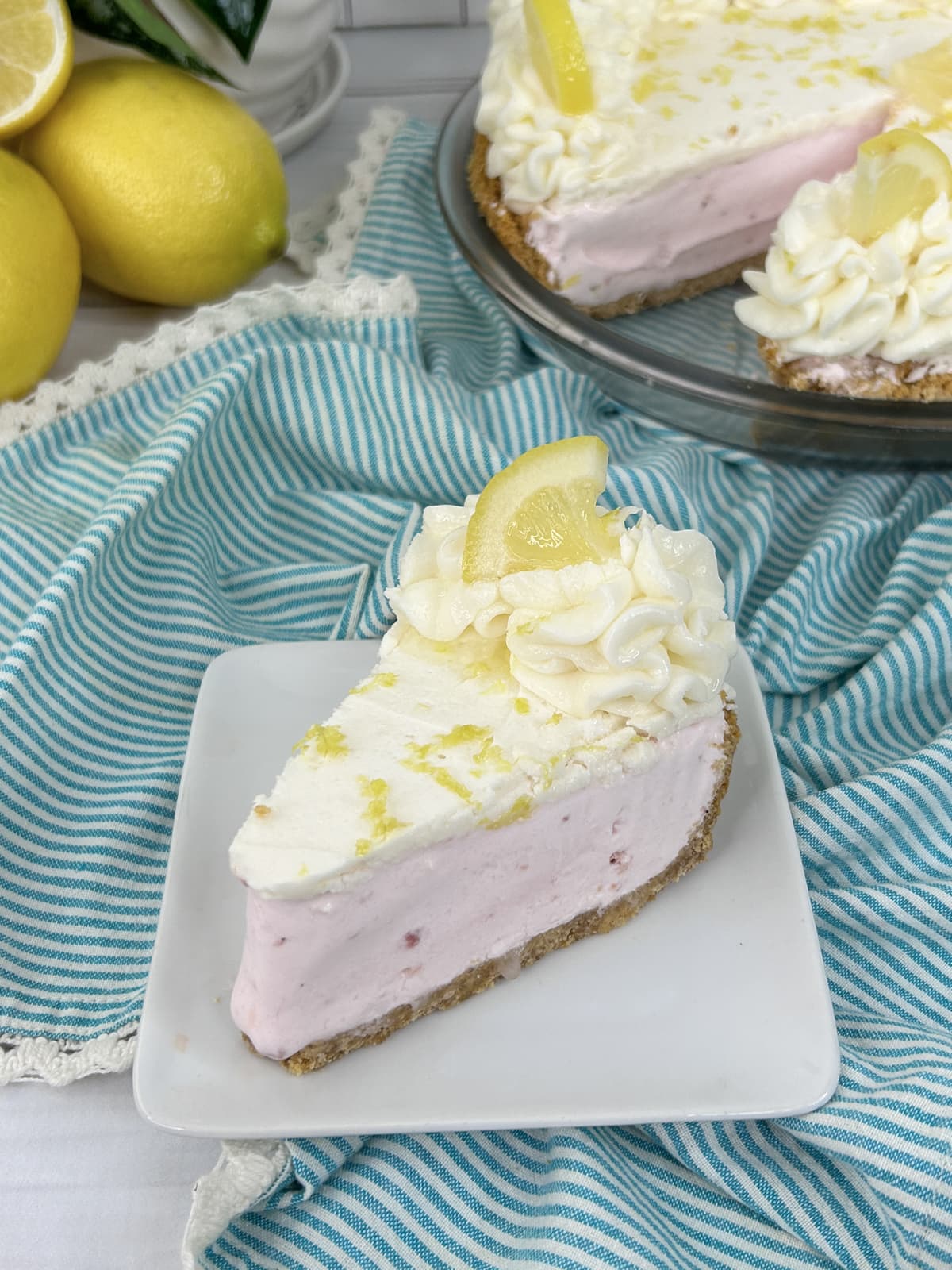 pink lemonade pie with fresh lemon on white plate