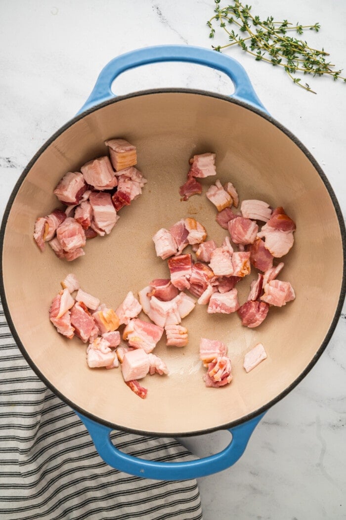 Pieces of thick cut bacon in a skillet