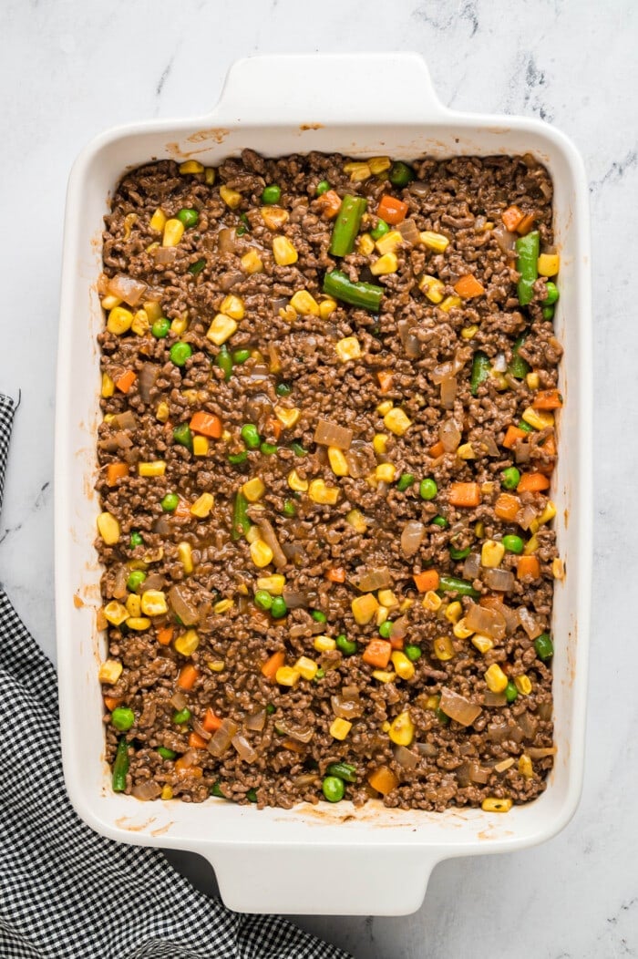 Ground beef and mixed veggies in a casserole dish