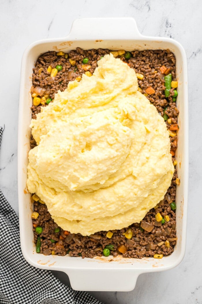 Mashed potatoes on top of ground beef and veggies