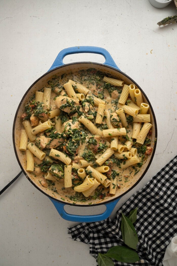 Tuscan chicken pasta ingredients in a skillet