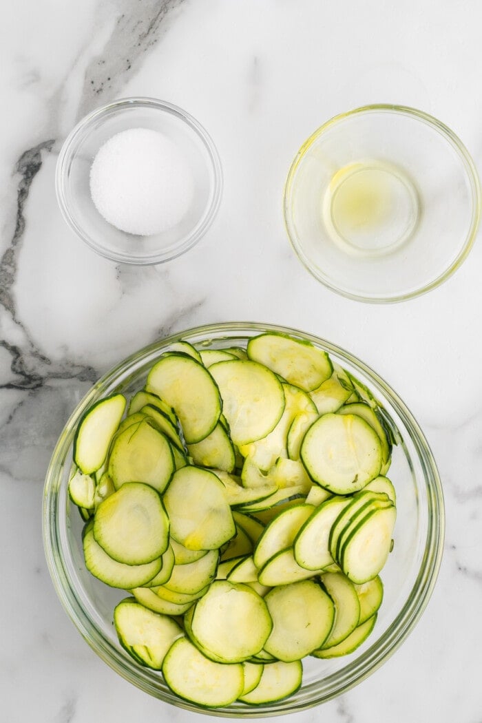zucchini chips in glass bowl with oil