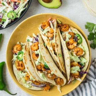 spicy shrimp tacos in yellow bowl with jalapeno coleslaw