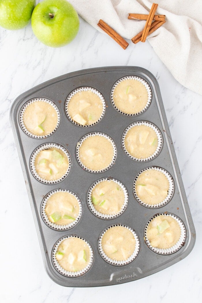 Apple muffin batter in a muffin tray