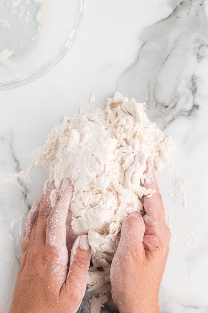 Hands kneading bagel dough