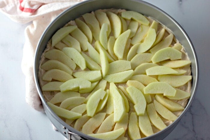 apple layer over cheesecake in pan