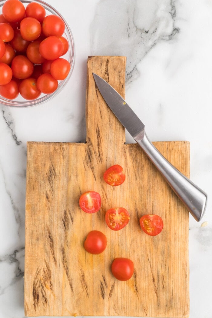 tomatoes sliced in half on cutting board