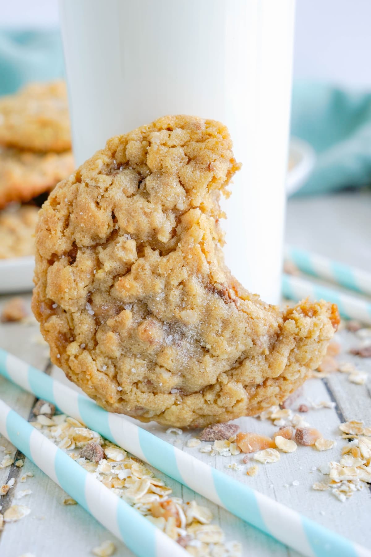 bite out of peanut butter oatmeal cookies with glass of milk