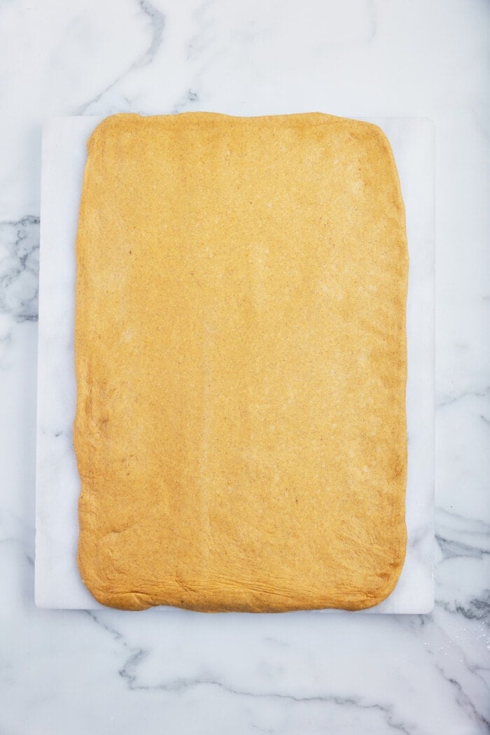 Cinnamon roll dough rolled out into a rectangle