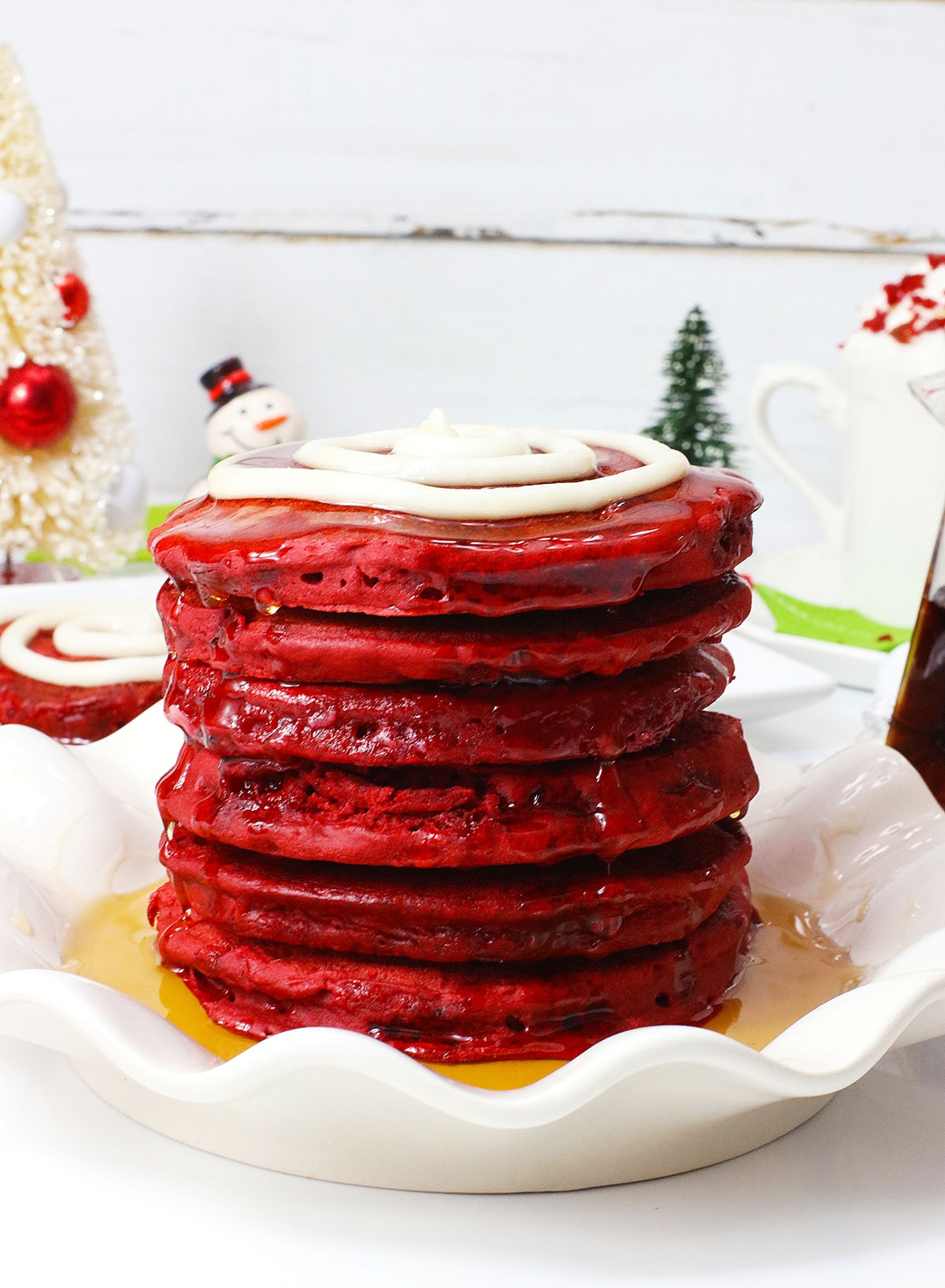 stack of red velvet pancakes on white plate with syrup