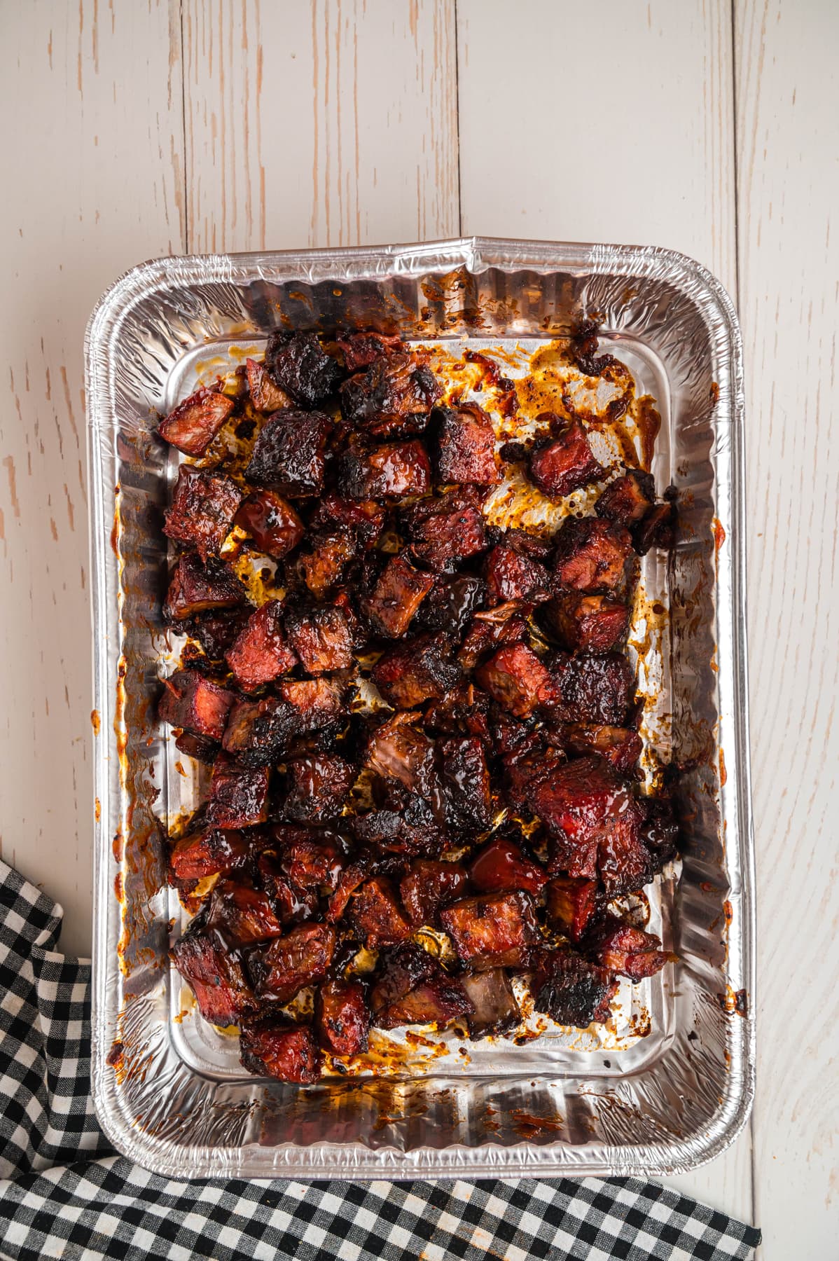 Overhead view of poor man's burnt ends in a foil pan