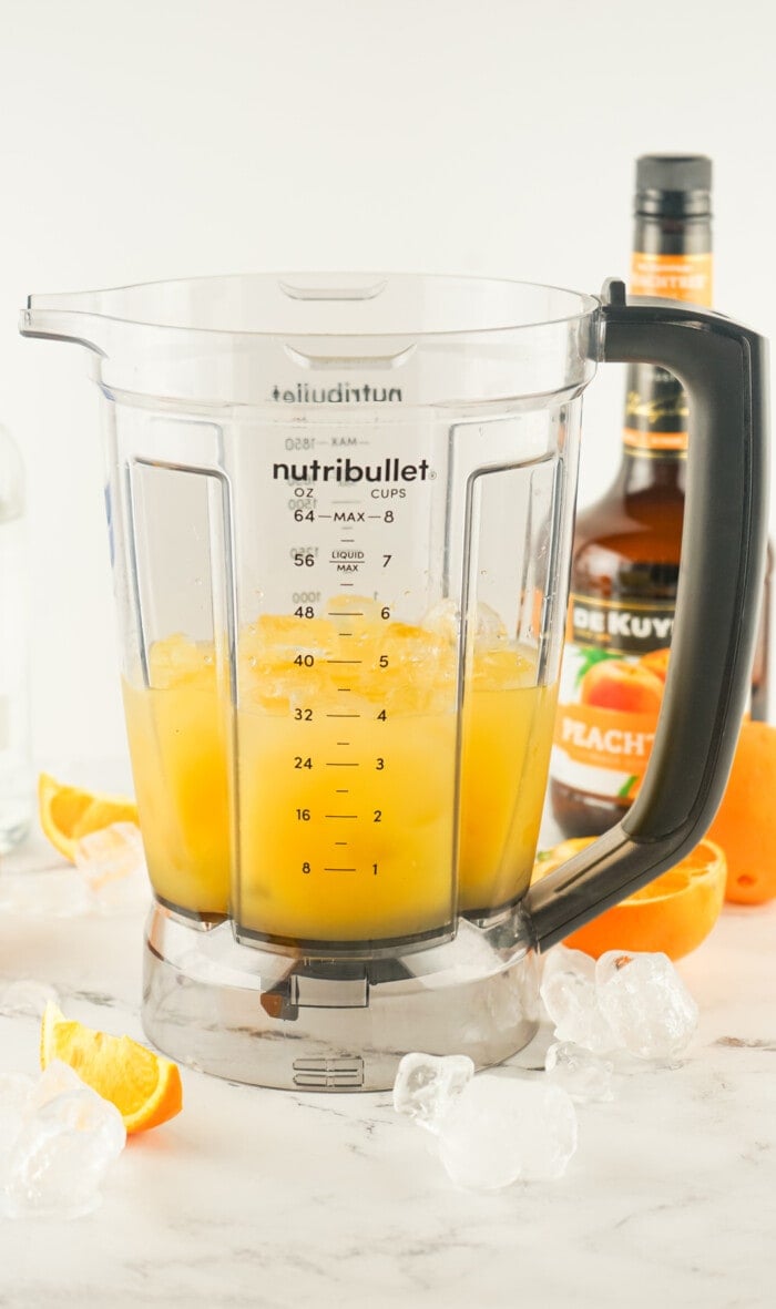 A blender of orange juice, vodka, and ice