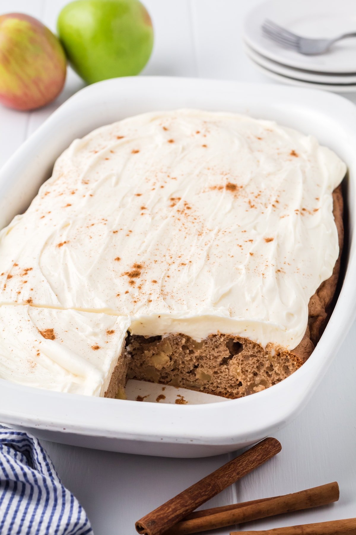 apple cake with frosting in white baking dish