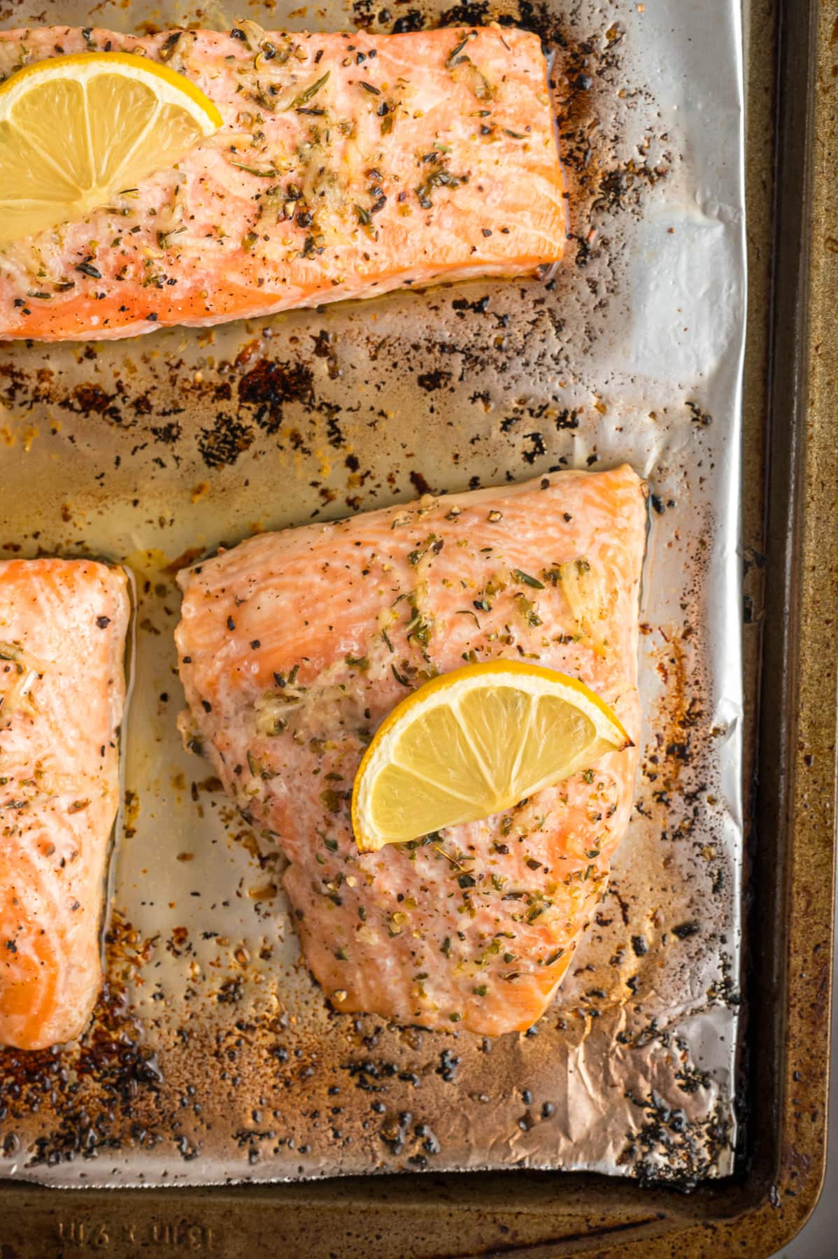 Close up of lemon salmon filets on a baking sheet