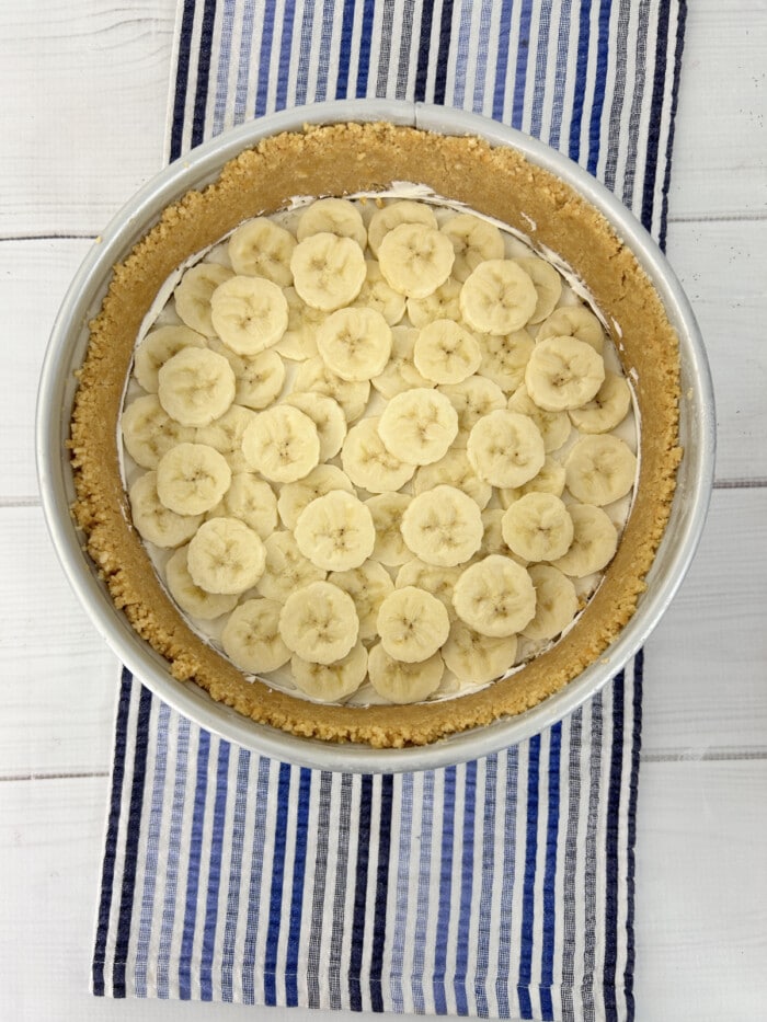 slices of banana on top of pudding in graham cracker crust