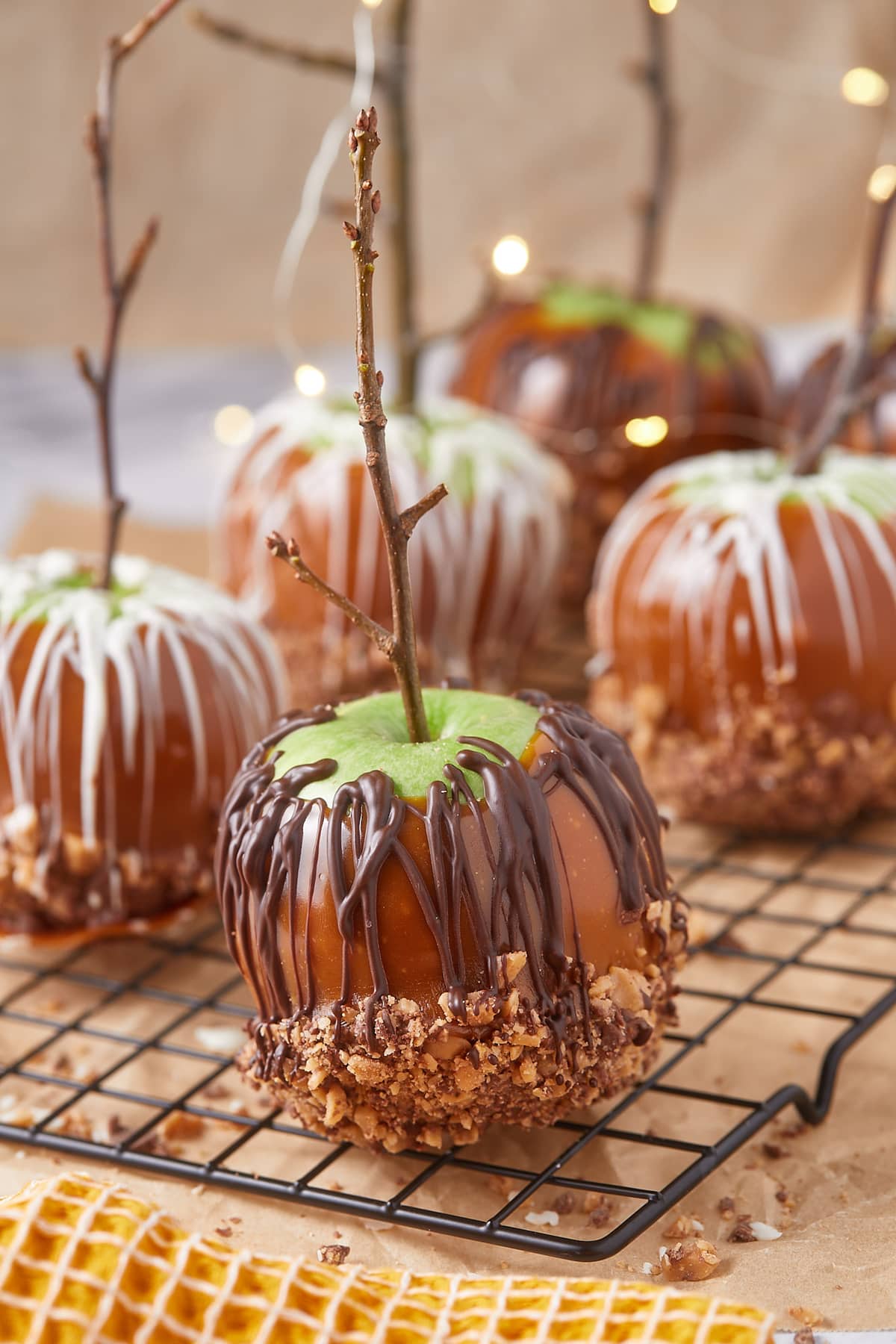 Homemade caramel apples with chocolate on a cooling rack