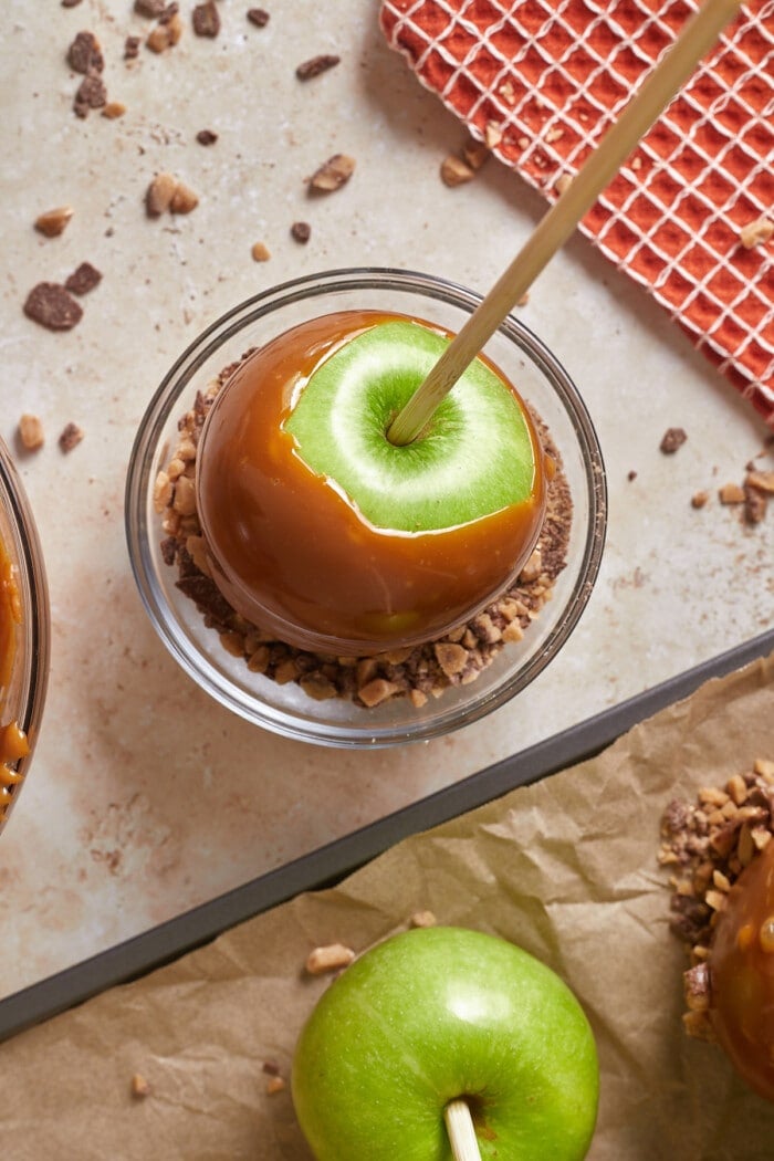 A caramel apple dipped into toffee bits