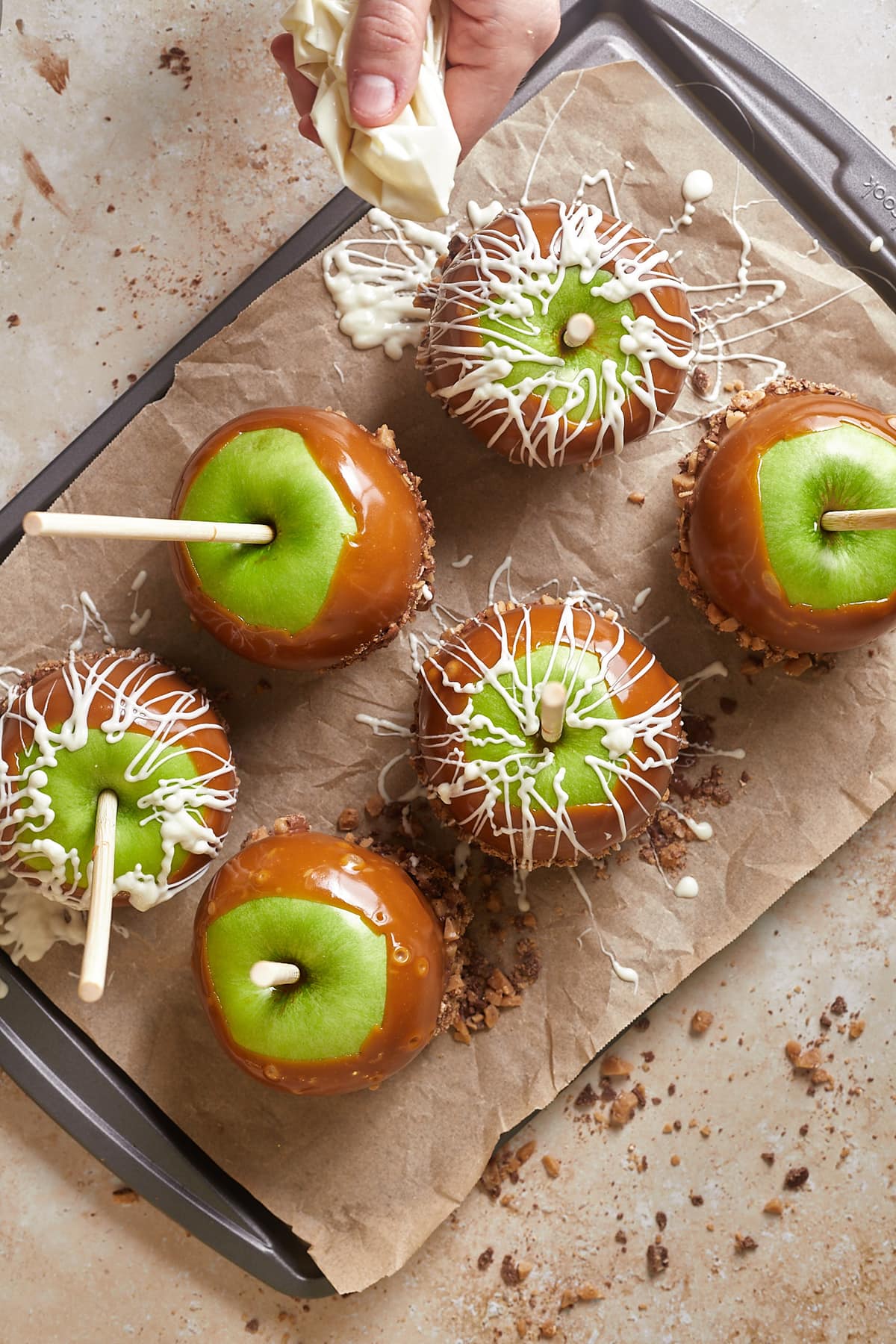 Overhead view of caramel apples on parchment paper