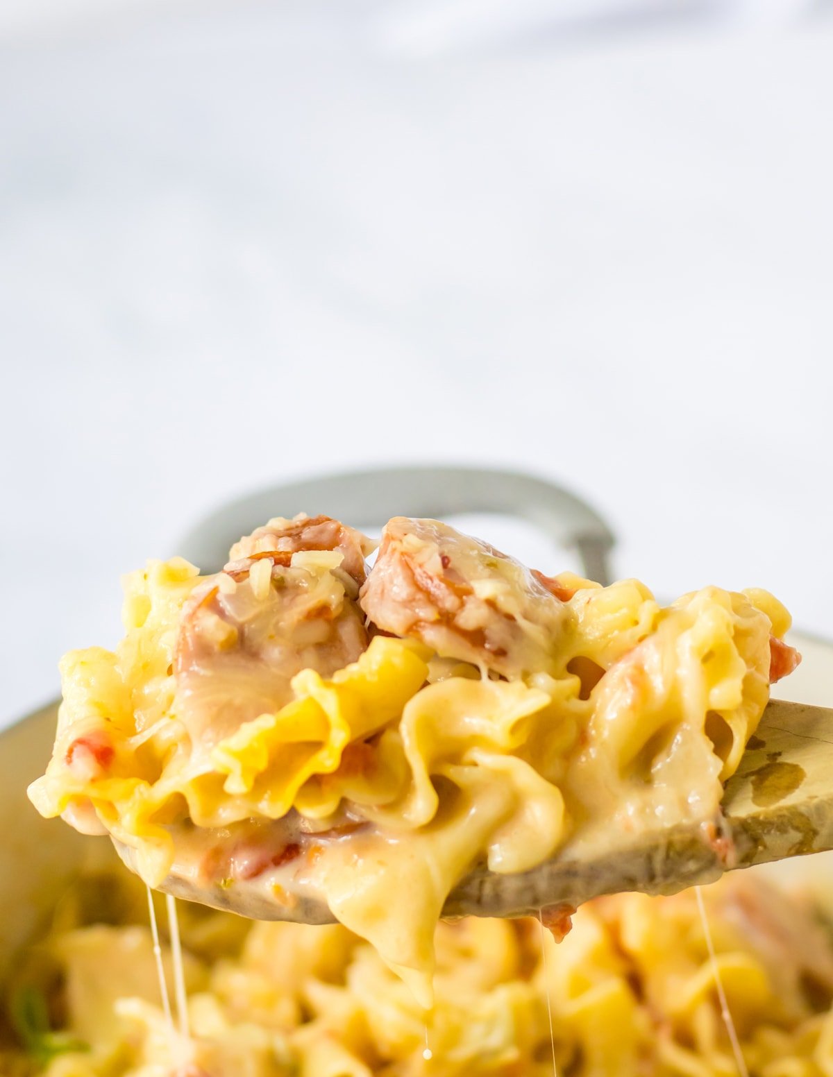 wooden spoon with creamy sausage pasta