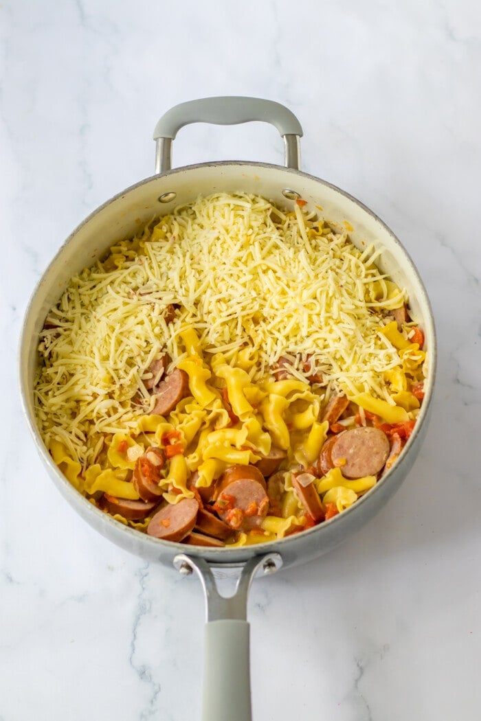 cheese in skillet with creamy sausage pasta