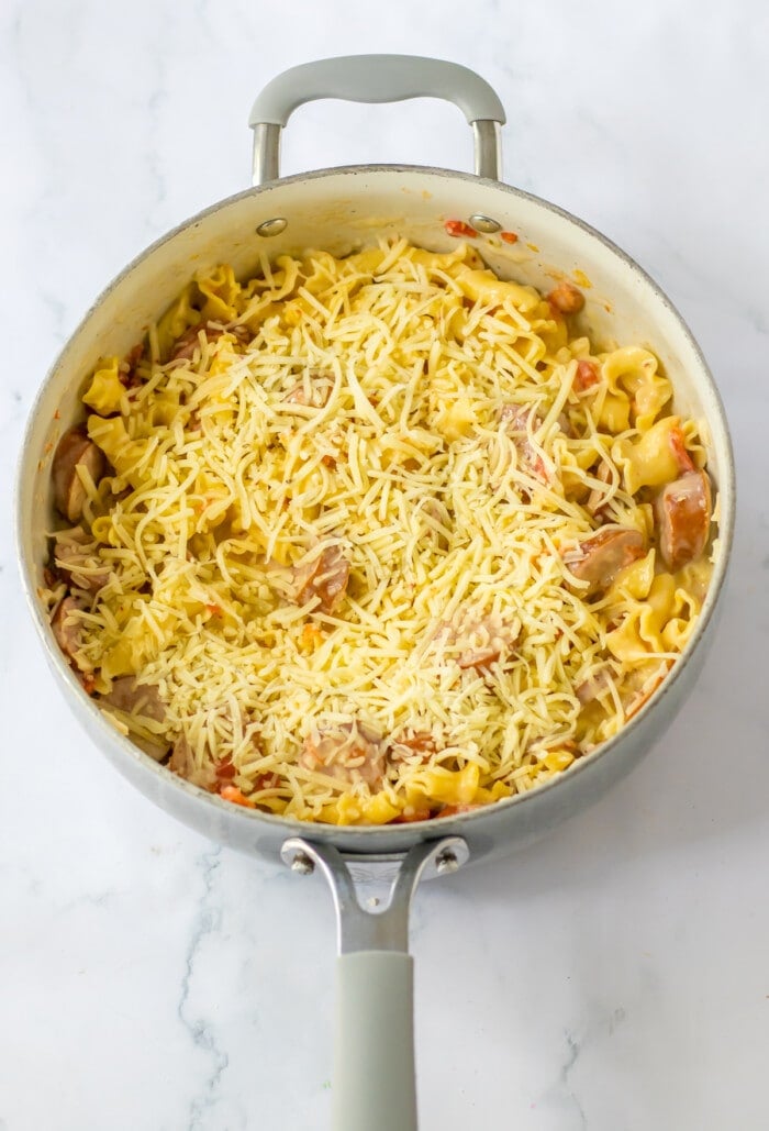 creamy sausage pasta cooked in skillet with cheese