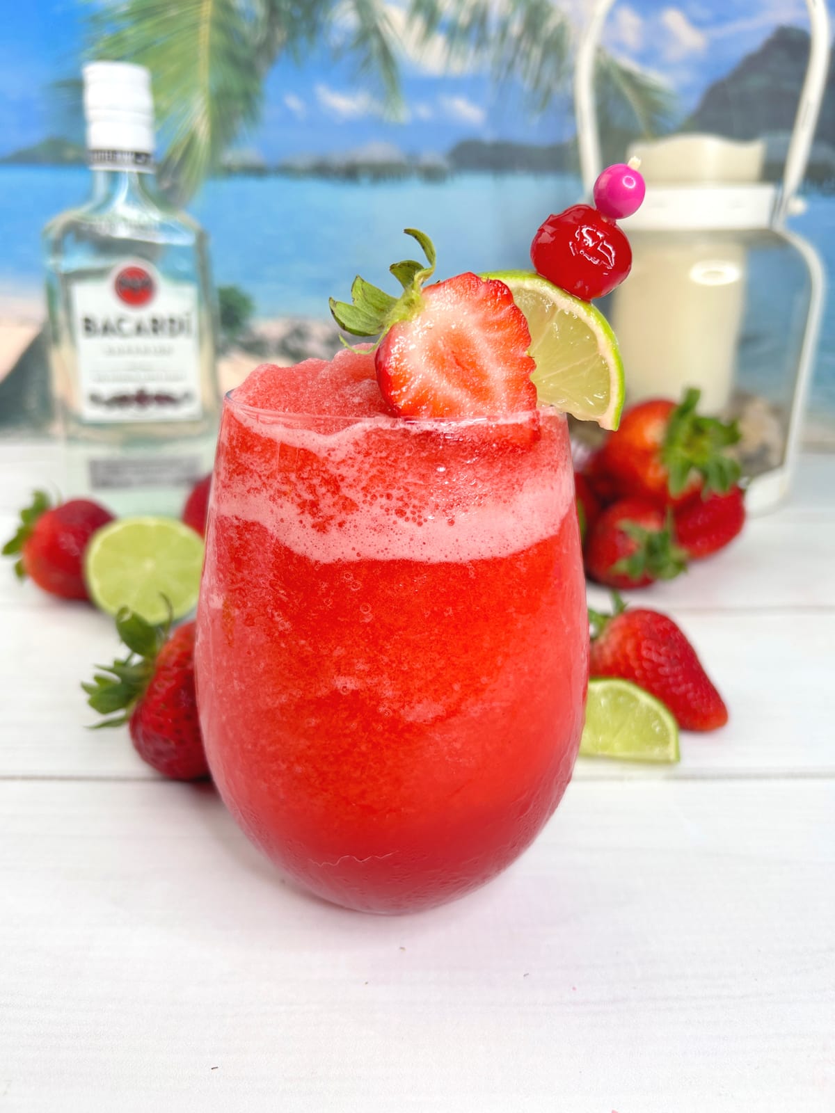 frozen strawberry daiquiri in glass with strawberry and lime for garnish