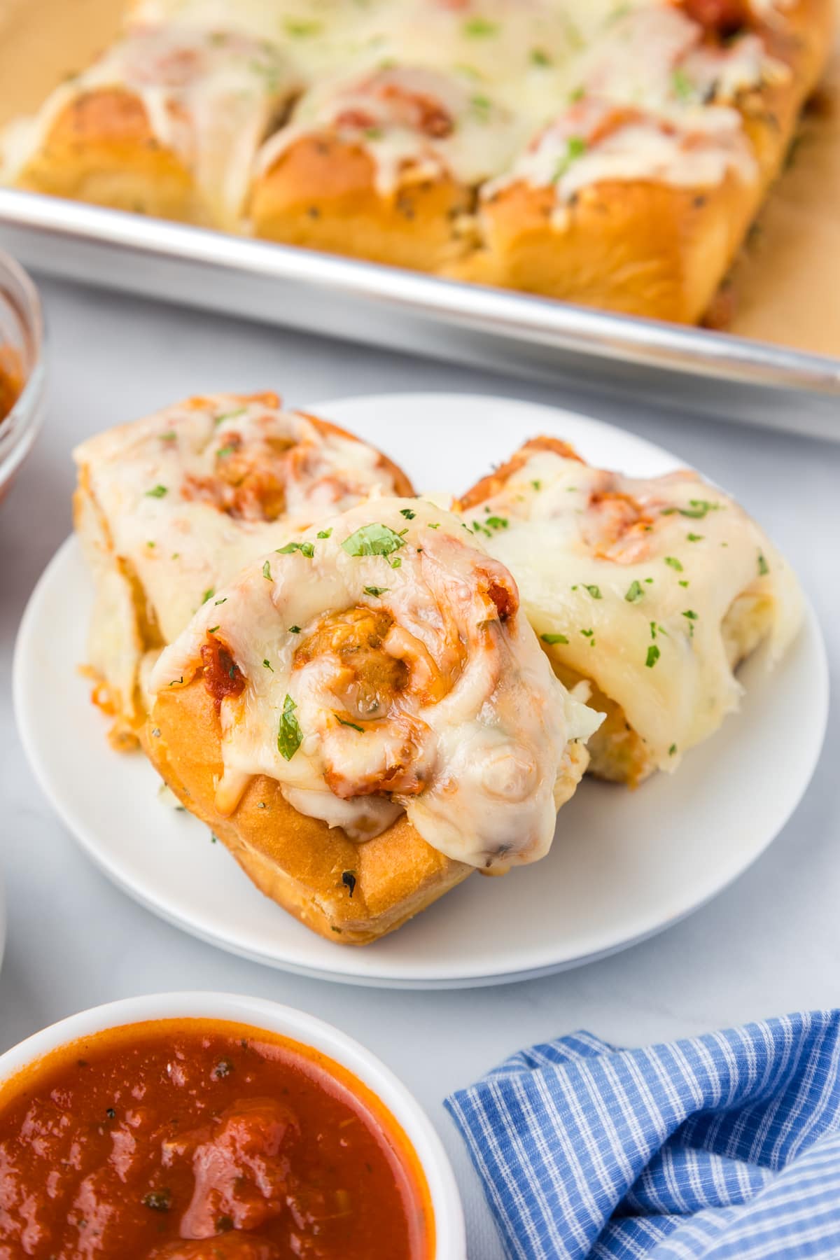 meatball sliders on white plate with marinara sauce