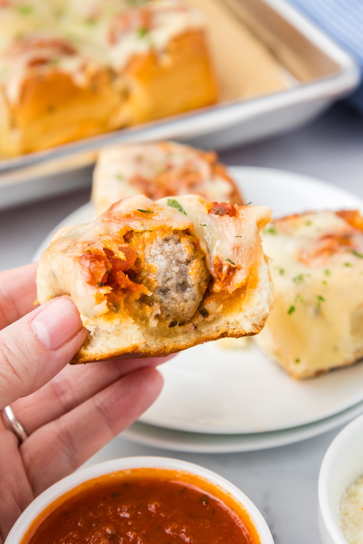 hand holding meatball slider with bite out