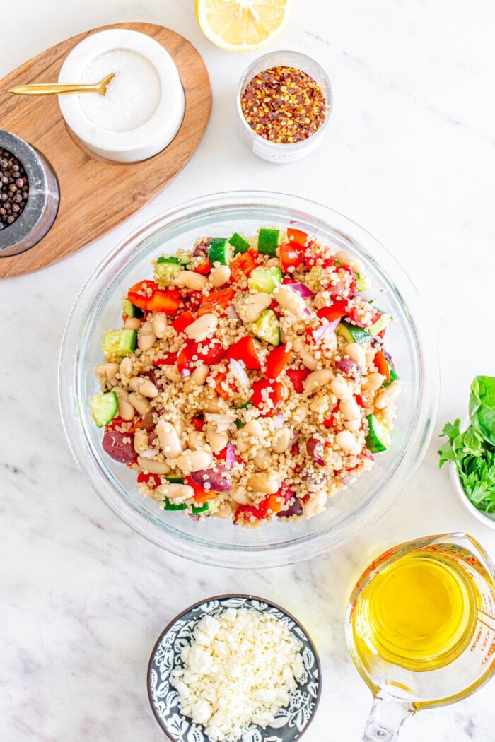 ingredients mixed in bowl for mediterranean quinoa salad