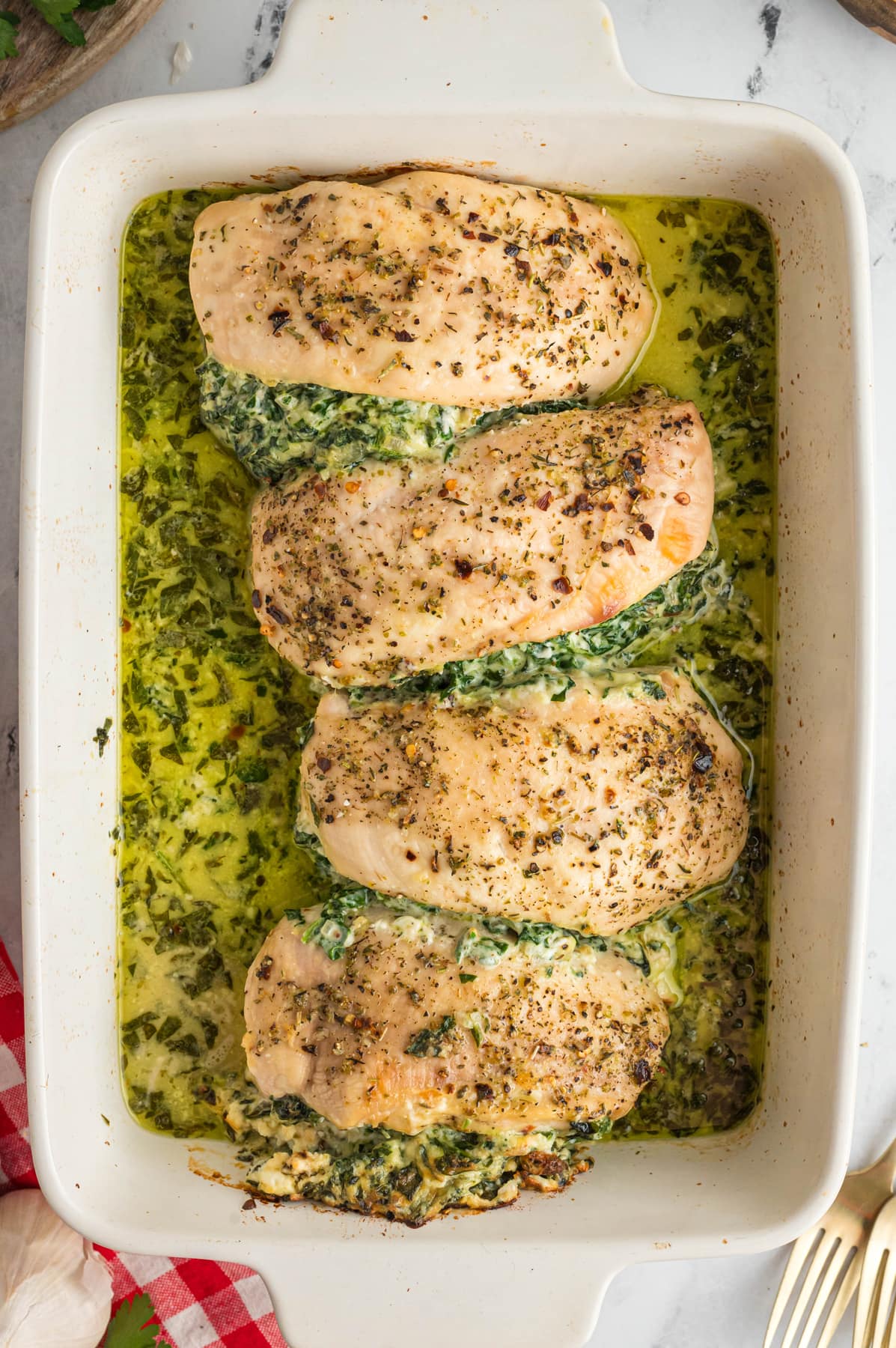 Overhead view of spinach stuffed chicken breasts in a baking dish