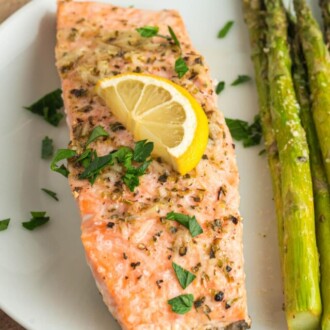 Oven baked salmon on a white plate with asparagus
