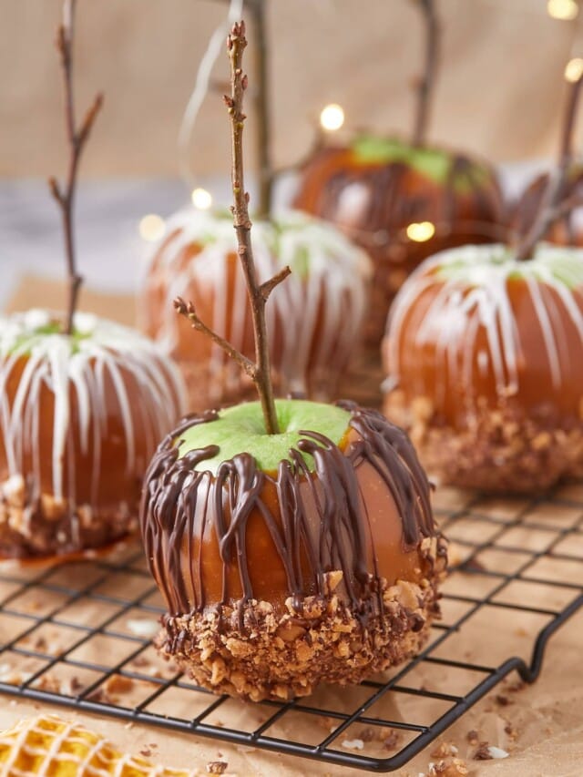 Homemade caramel apples with chocolate on a cooling rack