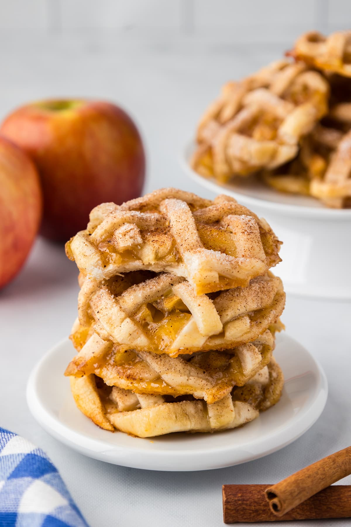 apple pie cookies with bite out stacked on white plate