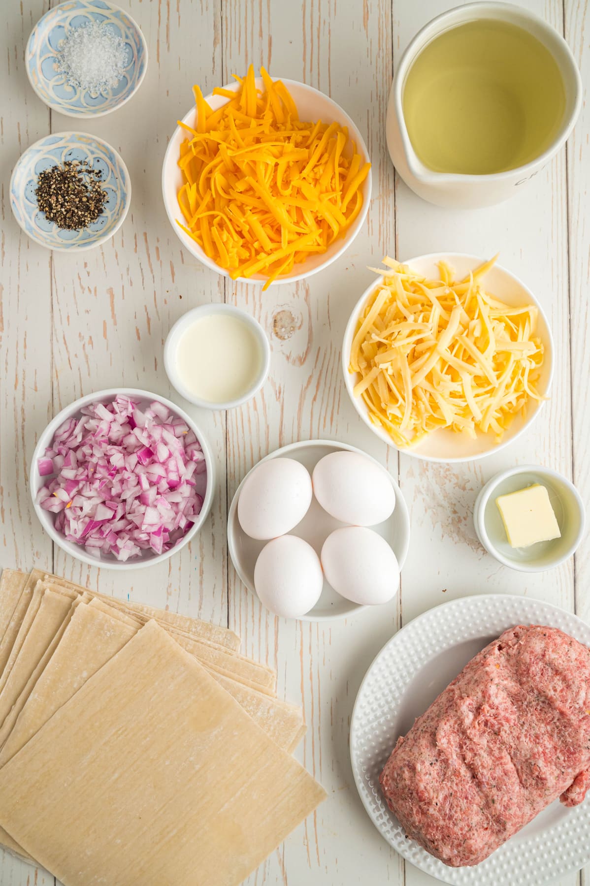 Ingredients to make breakfast egg rolls on a white background.