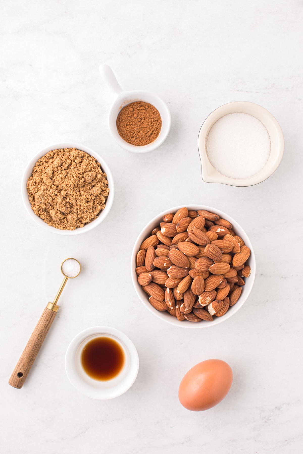 A bowl of almonds, eggs, sugar and other ingredients on a white background.