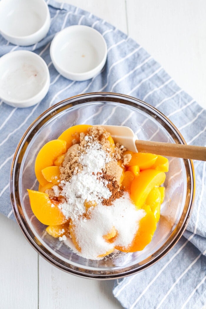 peaches in bowl with dry ingredients for cobbler