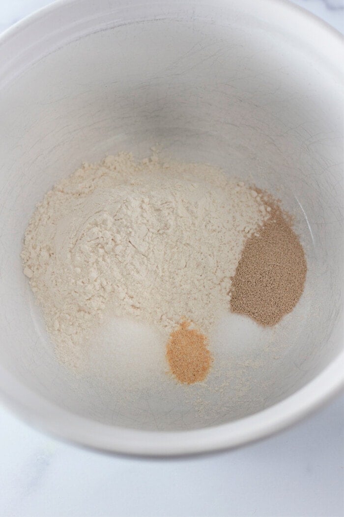 flour, yeast and dry ingredients in bowl to make homemade pizza dough