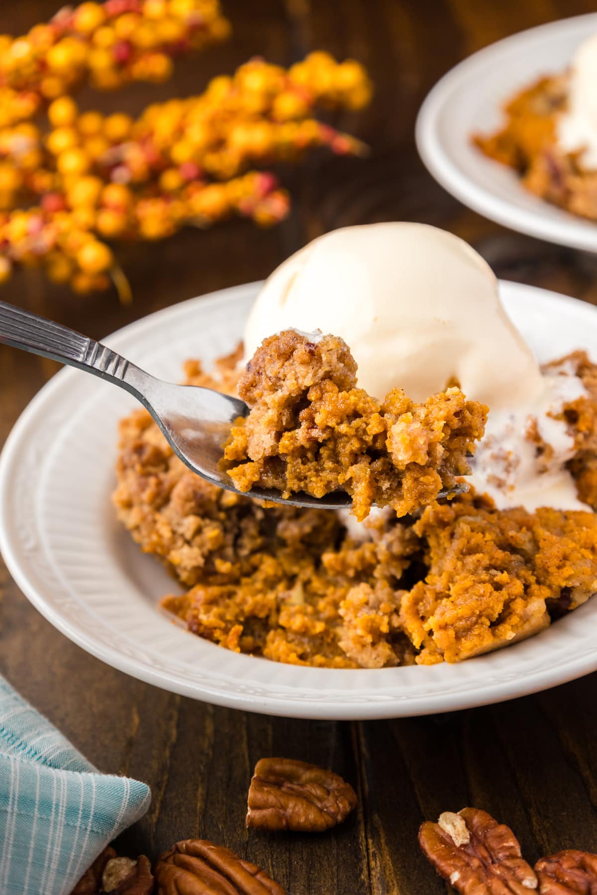 Pumpkin Crisp served with a scoop of vanilla ice cream on a white plate.