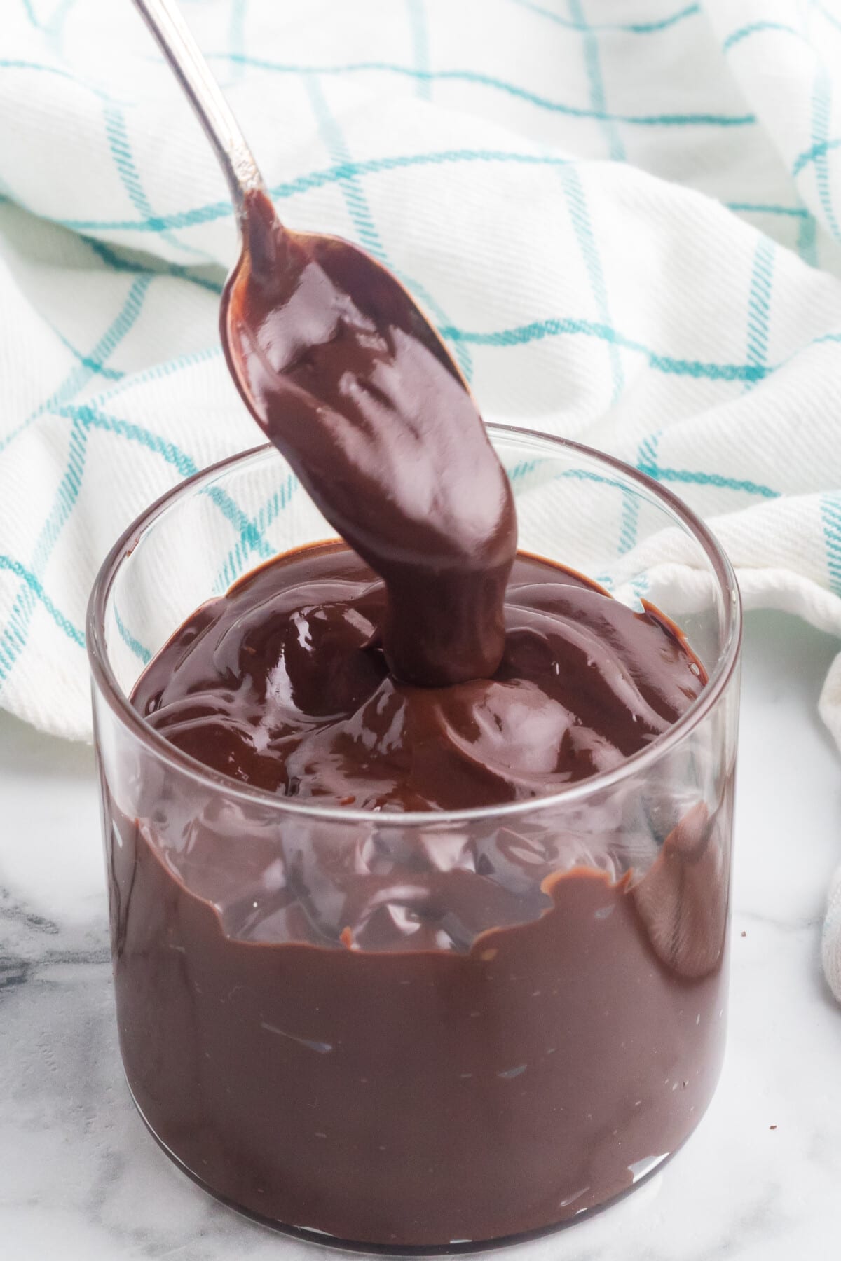 Spoon being dipped into chocolate ganache