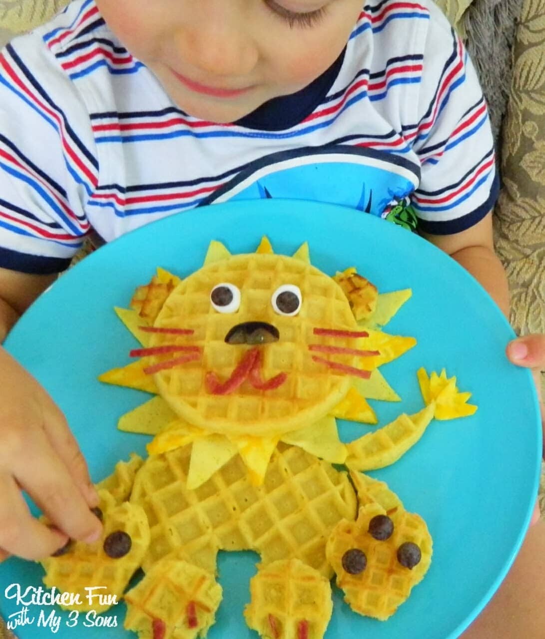 Boy with lion waffle breakfast on a blue plate