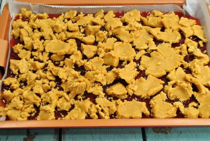 Peanut butter and jelly bars prepared in a pan ready to bake