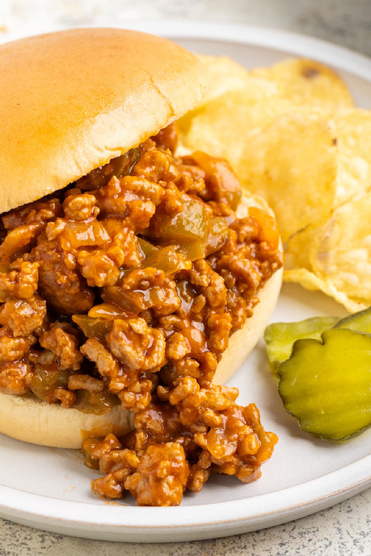 Turkey Sloppy Joes on a plate with chips and pickles