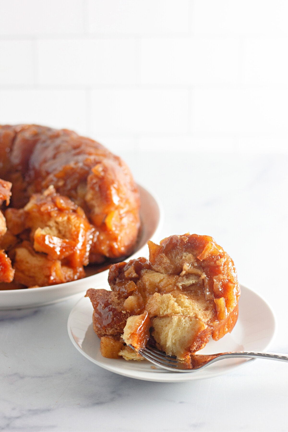apple fritter on a plate with a fork