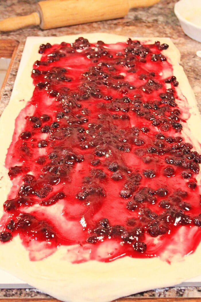 Spreading the blueberry filling on the dough