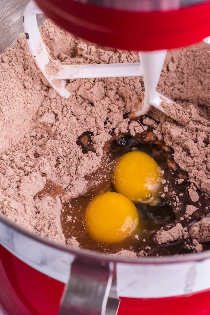 2 eggs being mixed into brownie mix.